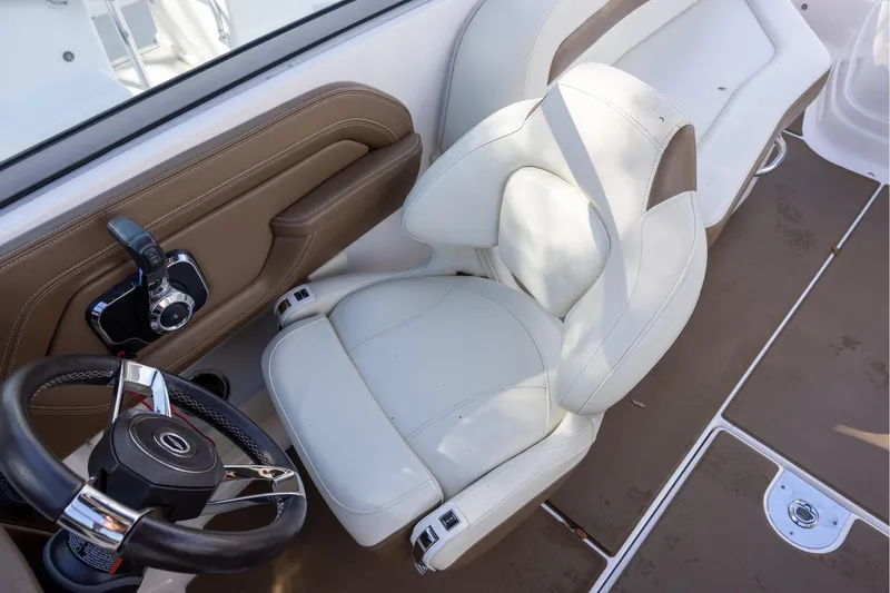 Slide: The Image of 2018 Chaparral 264 Sunesta boat interior with white captain's chair and steering wheel. - 8