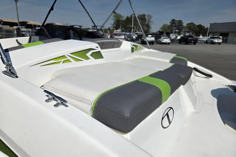 Slide: The Image of 2022 Tahoe T16 boat with green and gray seating, parked outdoors. - 11