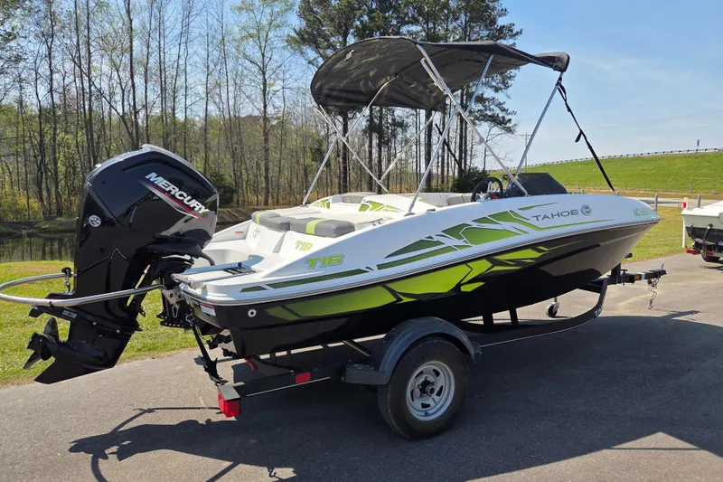 Slide: The Image of 2022 Tahoe T16 boat with Mercury engine on trailer, parked outdoors. - 2
