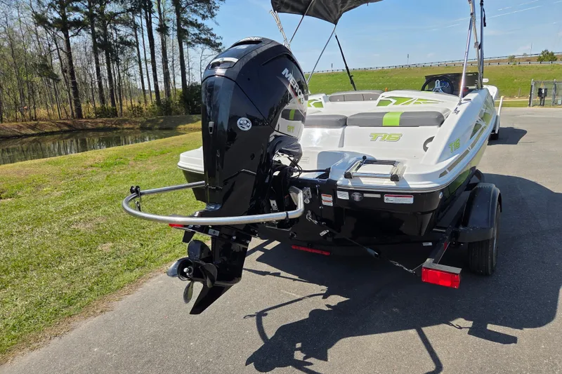 Slide: The Image of 2022 Tahoe T16 boat with outboard motor on trailer, parked near a pond. - 3