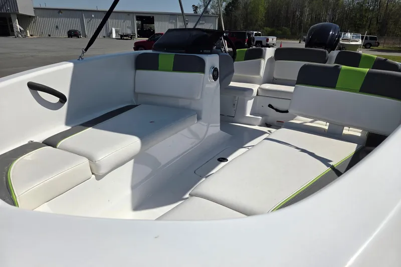 Slide: The Image of 2022 Tahoe T16 boat interior with white and green seating, parked outdoors. - 8