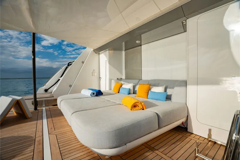 Slide: The Image of Luxurious sun deck with large loungers, colorful cushions, and towels on a modern yacht. - 13