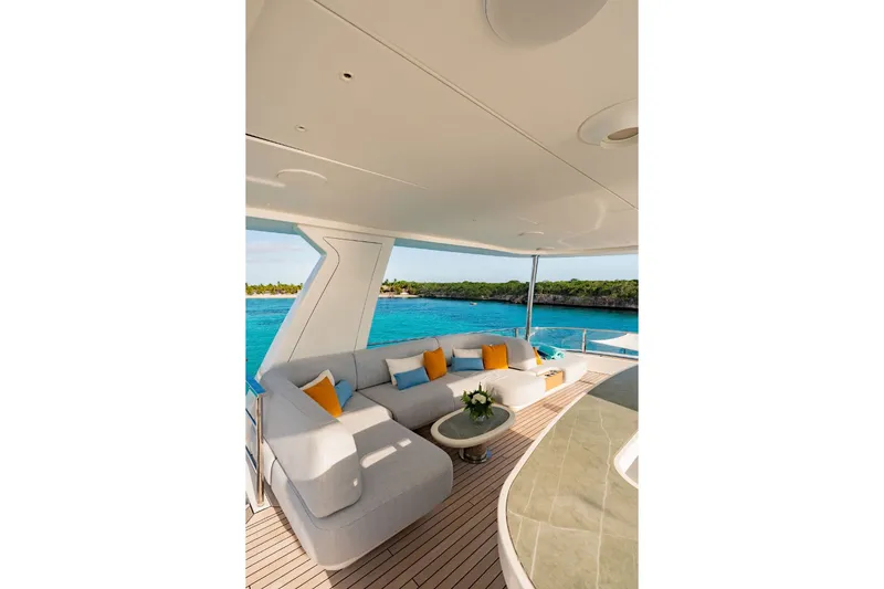 Slide: The Image of Luxurious yacht lounge with white sofas and yellow cushions, overlooking the sea. - 8