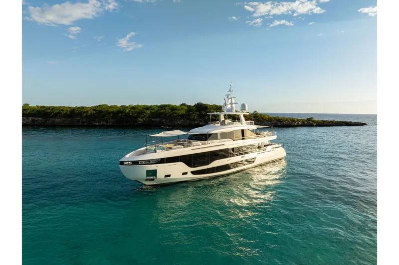 Slide: The Image of The 2024 Azimut Grande 36M cruising on calm waters near a wooded coastline. - 1