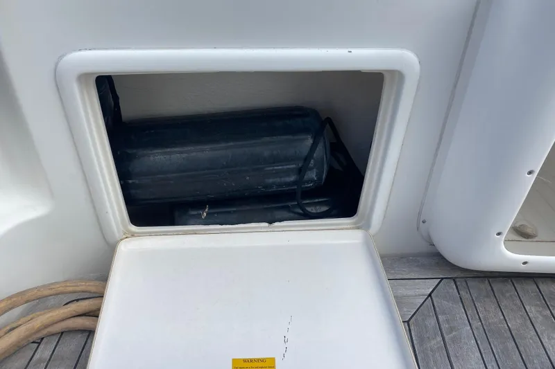 Slide: The Image of Storage compartment on a 2000 Riviera 4000 boat, containing black equipment. - 10