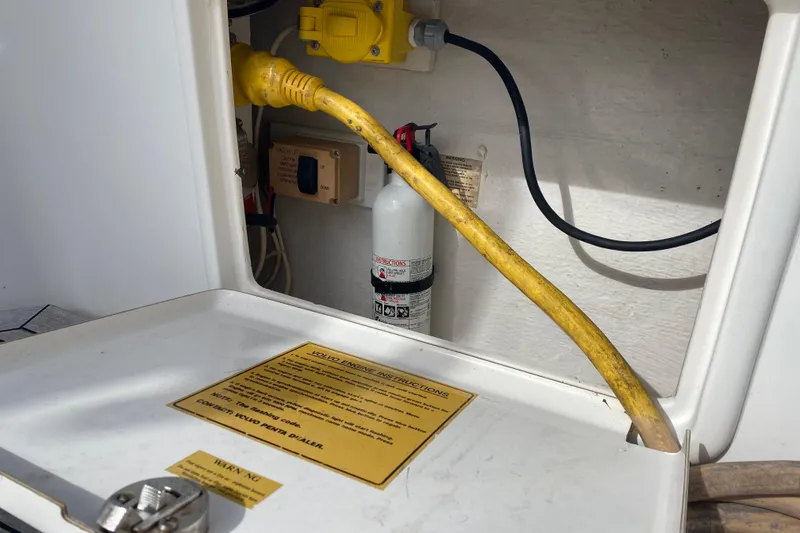 Slide: The Image of Electrical compartment of 2000 Riviera 4000 with yellow power cable and fire extinguisher. - 14