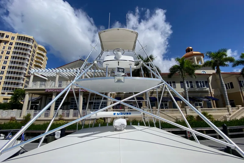 Slide: The Image of Riviera 4000 yacht docked near luxury buildings and palm trees, under a clear blue sky. - 22