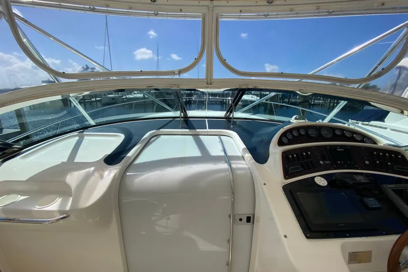 Slide: The Image of Cockpit view of a 2000 Riviera 4000 yacht with clear skies and marina backdrop. - 30