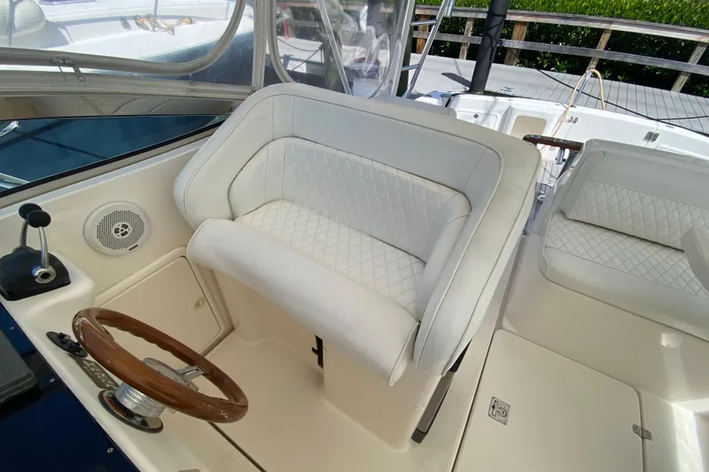 Slide: The Image of Luxurious 2000 Riviera 4000 yacht interior with white leather seating and wooden steering wheel. - 31