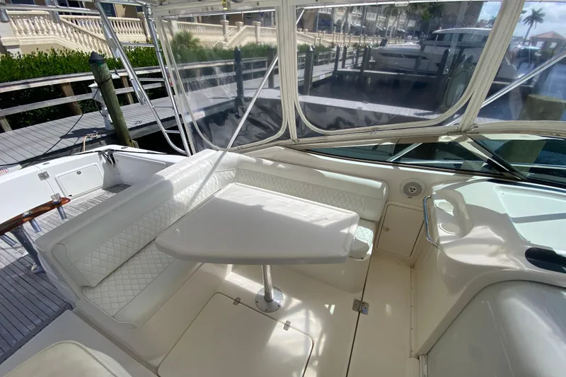 Slide: The Image of 2000 Riviera 4000 yacht interior with white seating and table, docked at marina. - 33