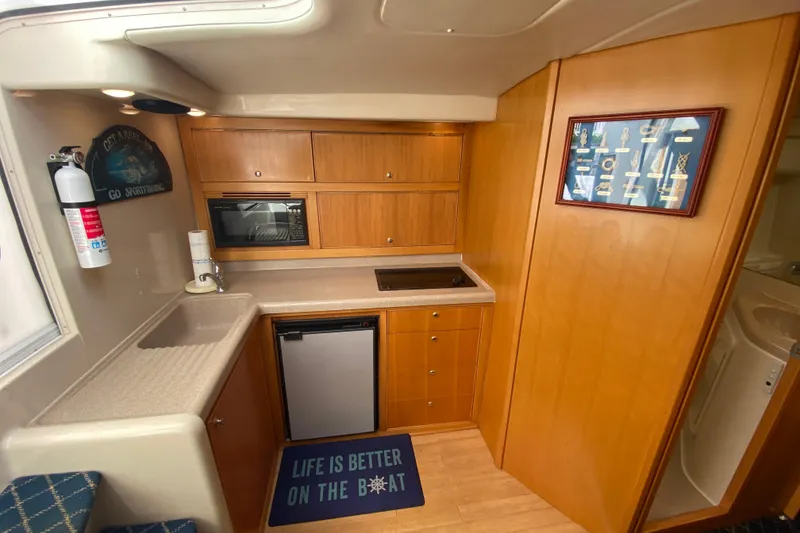 Slide: The Image of Interior of a 2000 Riviera 4000 yacht kitchen with wood cabinetry and modern appliances. - 41