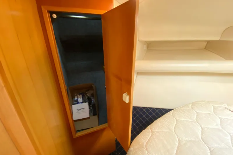 Slide: The Image of Interior of 2000 Riviera 4000 yacht showing open closet and bed area. - 53