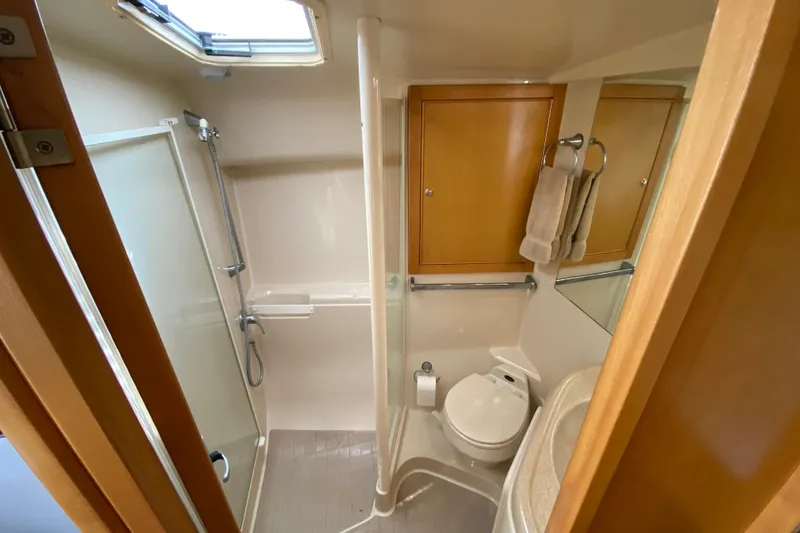 Slide: The Image of Bathroom interior of 2000 Riviera 4000 yacht with shower, toilet, and wooden cabinets. - 54