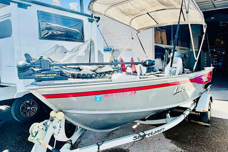 The Image of 2006 Lund 1625 Classic SS fishing boat on trailer, parked beside RV. - 1