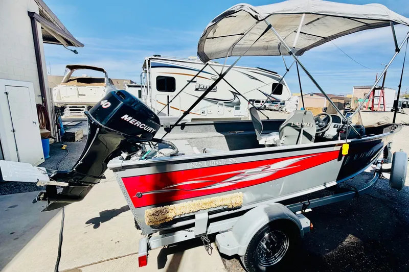 Slide: The Image of 2006 Lund 1625 Classic SS boat with Mercury engine on trailer, parked outdoors. - 5