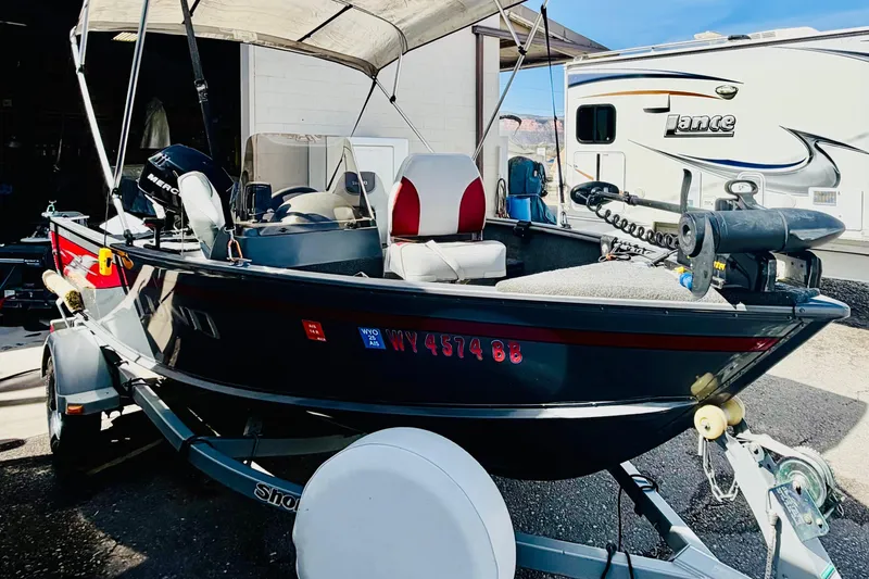 Slide: The Image of 2006 Lund 1625 Classic SS boat on trailer, parked near RV, under canopy. - 6