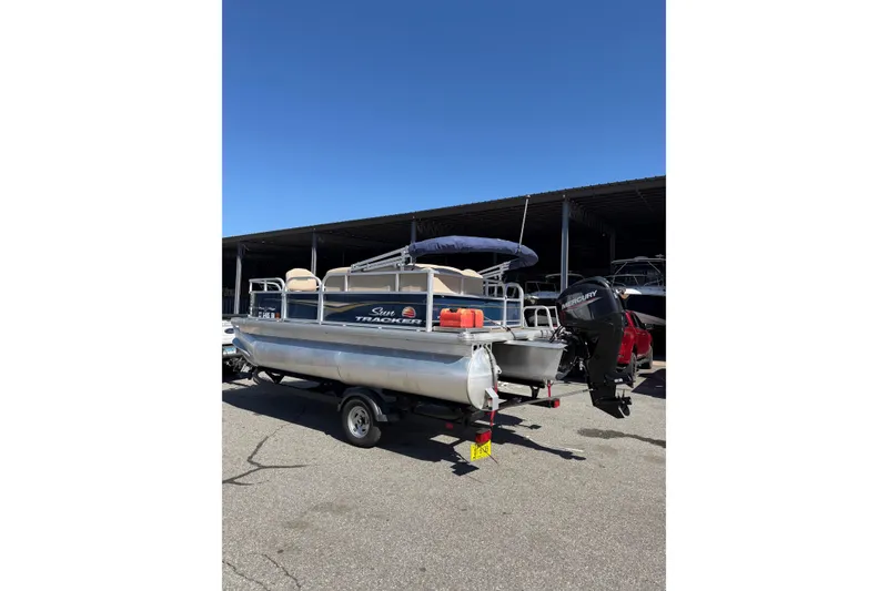 Slide: The Image of 2022 Sun Tracker Bass Buggy 16 XL pontoon boat parked outdoors. - 3
