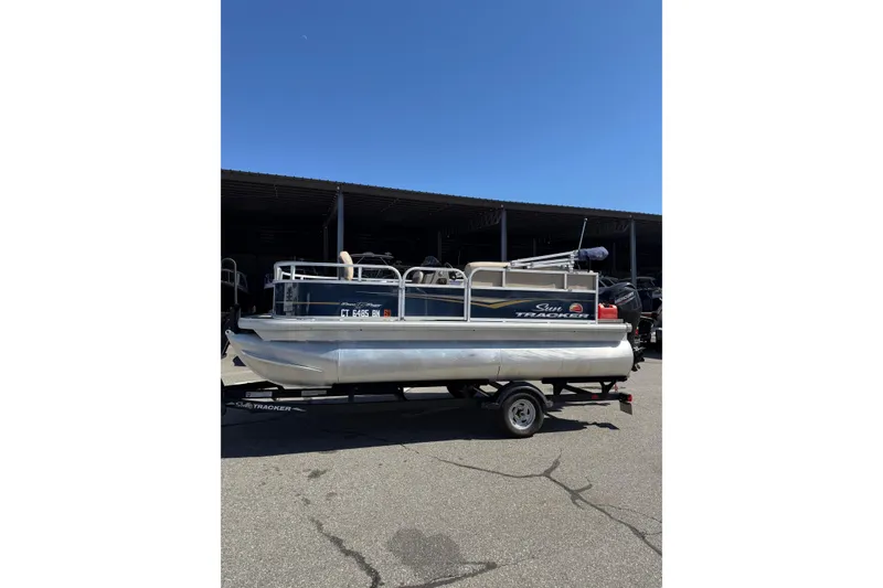 Slide: The Image of 2022 Sun Tracker Bass Buggy 16 XL pontoon boat on trailer in parking lot. - 4