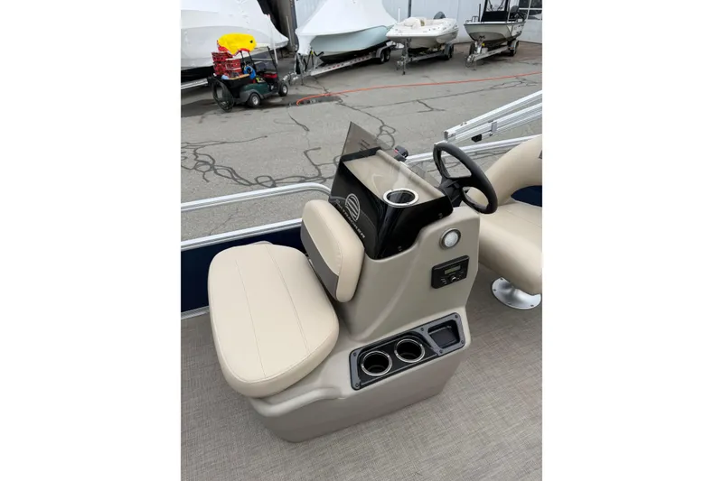 Slide: The Image of 2022 Sun Tracker Bass Buggy 16 XL boat console with beige seating and steering wheel. - 8