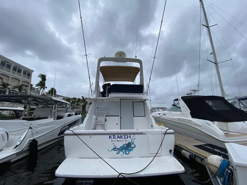 Slide: The Image of 2001 Bayliner 3988 yacht named "Kraken" docked at marina under cloudy skies. - 1