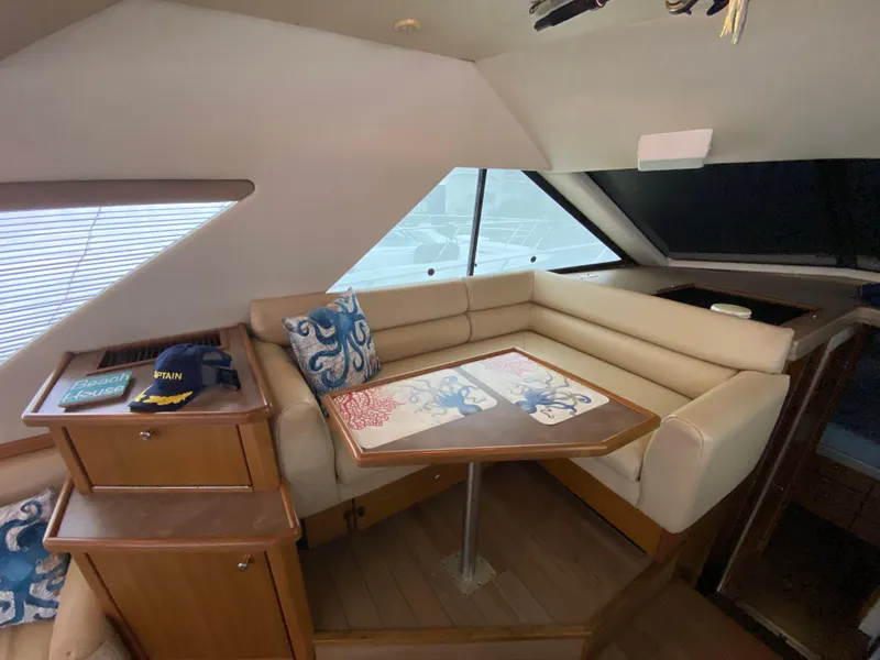 Slide: The Image of Interior of 2001 Bayliner 3988 yacht with beige seating and wooden table. - 12