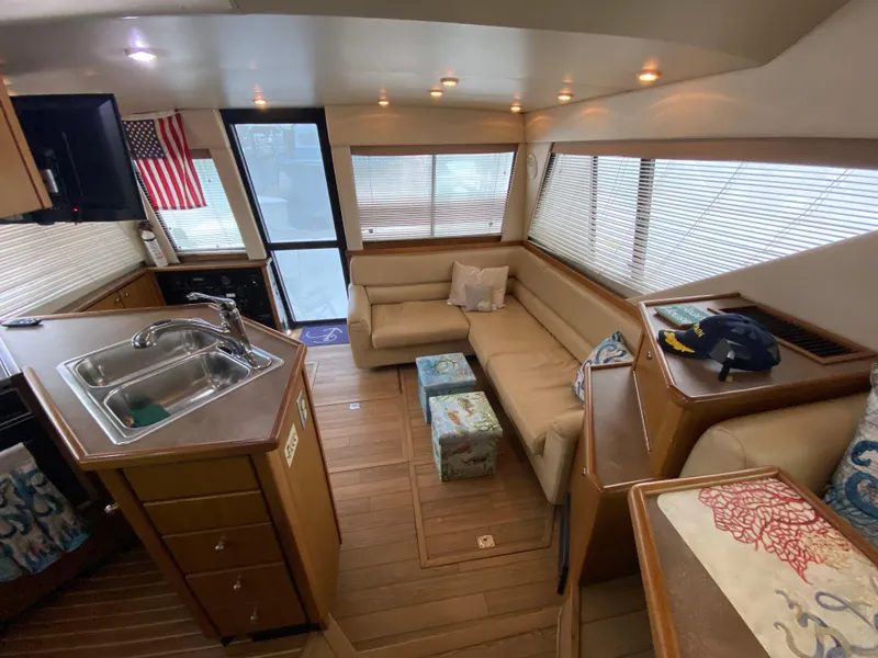 Slide: The Image of Interior of 2001 Bayliner 3988 yacht with cozy seating and kitchen area. - 13
