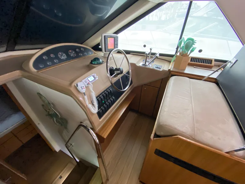 Slide: The Image of 2001 Bayliner 3988 helm with steering wheel, control panel, and navigation equipment. - 17