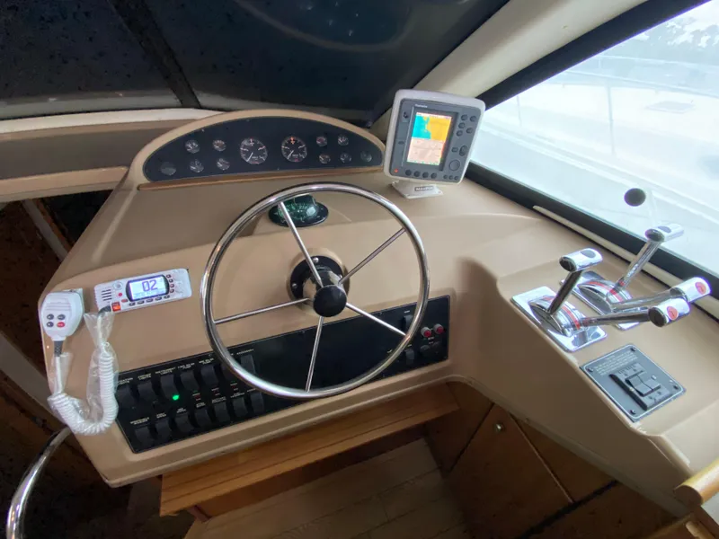 Slide: The Image of 2001 Bayliner 3988 helm with steering wheel, controls, and navigation display. - 18