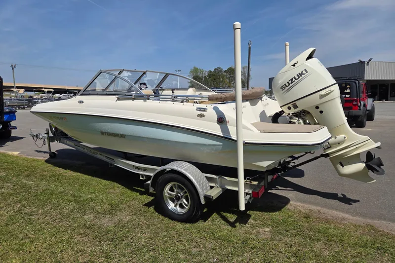 Slide: The Image of 2017 Stingray 191 DC boat with Suzuki outboard motor on trailer, parked outdoors. - 5