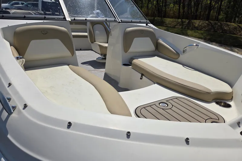 Slide: The Image of 2017 Stingray 191 DC boat interior with beige seating and wood accents. - 8