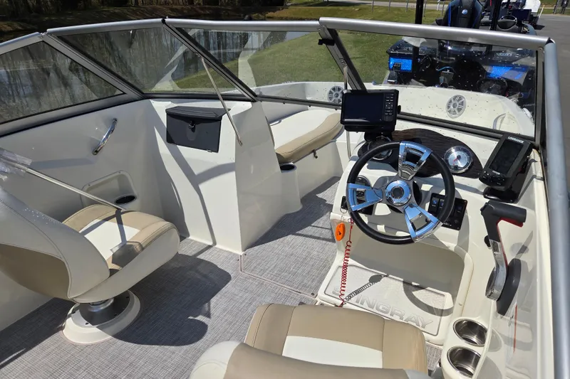 Slide: The Image of 2017 Stingray 191 DC boat interior with steering wheel, seating, and navigation equipment. - 9