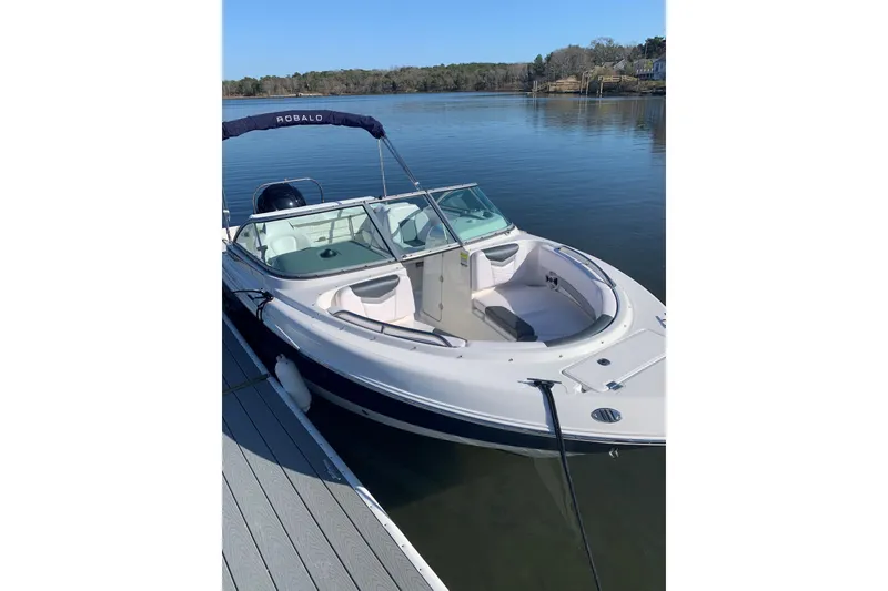 Slide: The Image of 2021 Robalo R227 Dual Console boat docked on calm water. - 1