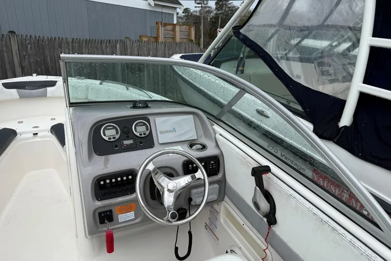 Slide: The Image of 2021 Robalo R227 Dual Console boat cockpit with steering wheel and Garmin display. - 5