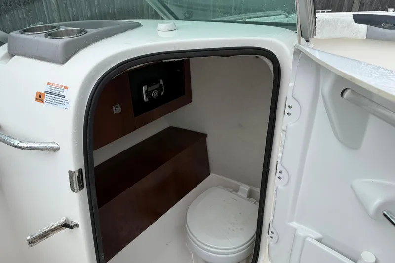 Slide: The Image of 2021 Robalo R227 Dual Console boat interior with compact marine toilet. - 6