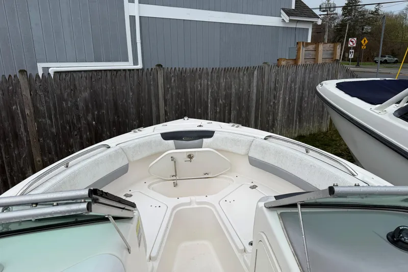 Slide: The Image of 2021 Robalo R227 Dual Console boat, bow seating area, parked near wooden fence. - 8