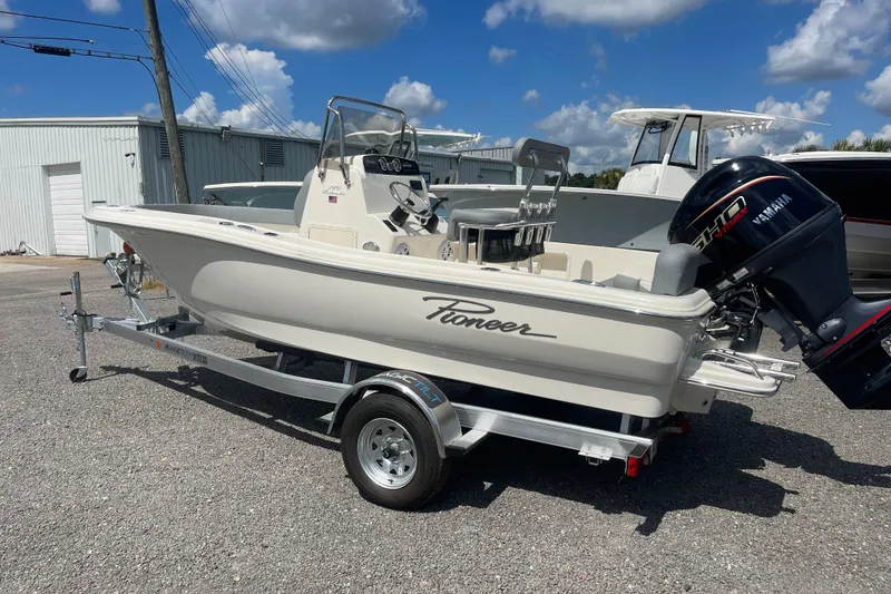 The Image of 2026 Pioneer 180 Islander boat on trailer with Yamaha outboard motor, parked outdoors. - 0
