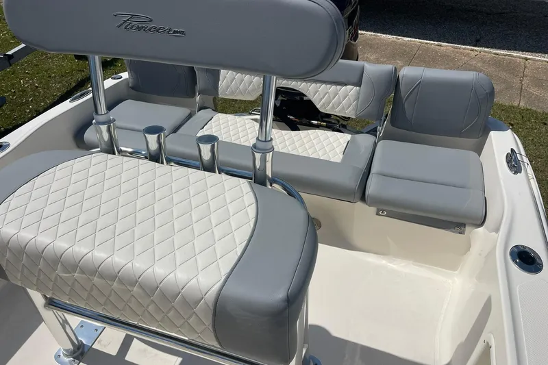 Slide: The Image of 2026 Pioneer 180 Islander boat interior with gray and white cushioned seating. - 2