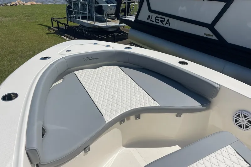 Slide: The Image of 2026 Pioneer 180 Islander boat interior with cushioned seating and cup holders. - 4