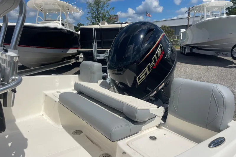 Slide: The Image of 2026 Pioneer 180 Islander boat with Yamaha outboard motor, parked among other boats. - 11