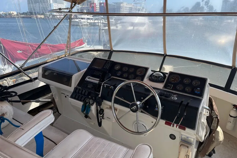 Slide: The Image of 1992 Carver 33 Aft Cabin Motor Yacht helm with steering wheel and navigation instruments. - 5