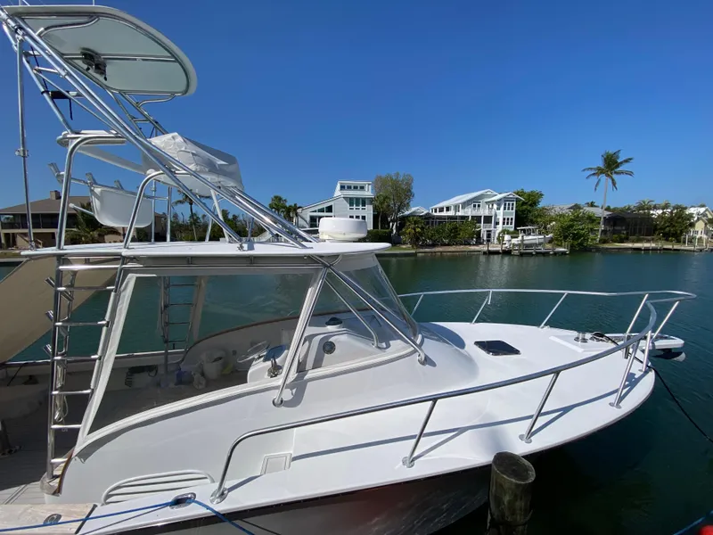 Slide: The Image of 1995 L&H 33 boat docked by waterfront homes under clear blue sky. - 3