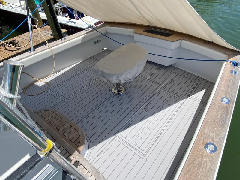 Slide: The Image of Spacious deck of a 1995 L&H 33 boat with covered seating and wooden flooring. - 33