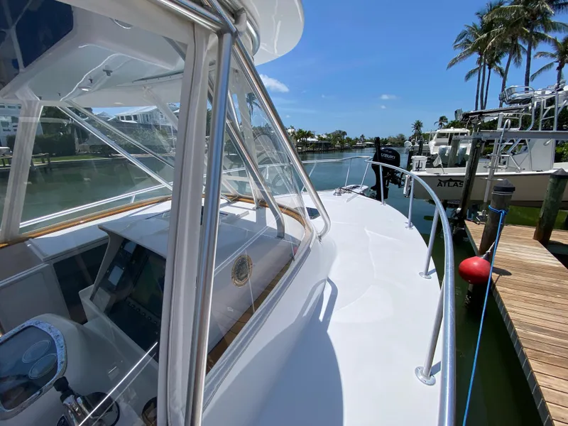 Slide: The Image of 1995 L&H 33 boat docked by a scenic waterfront with palm trees. - 35