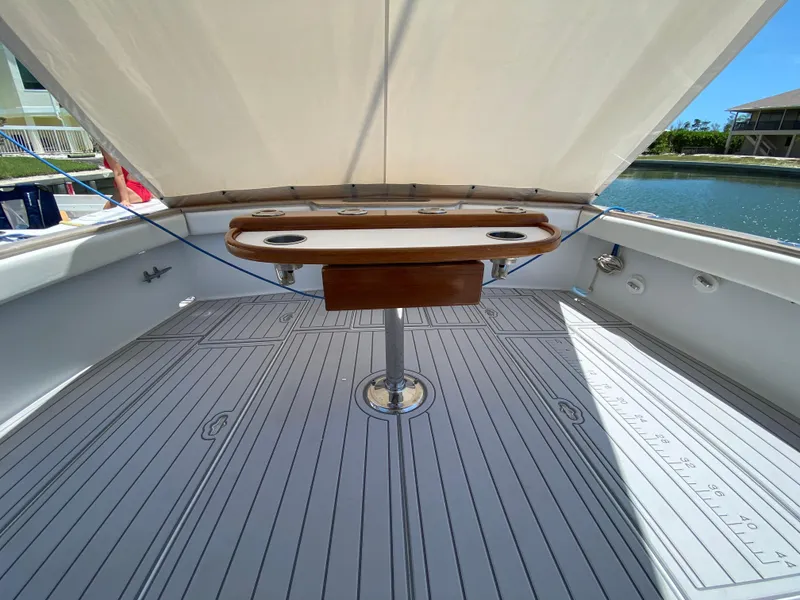 Slide: The Image of 1995 L&H 33 boat deck with wooden table, under canopy, near waterfront. - 37