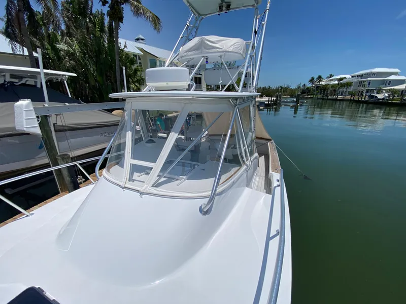 Slide: The Image of 1995 L&H 33 boat docked in a serene marina under clear blue skies. - 6
