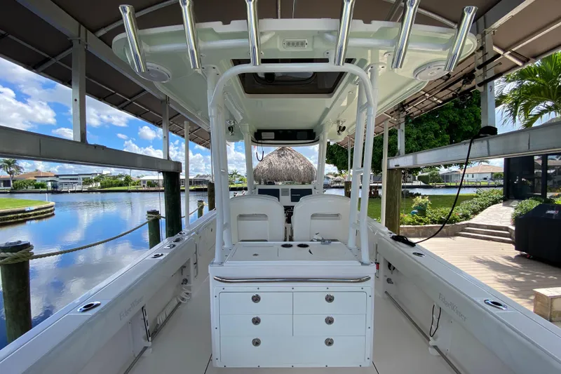 Slide: The Image of 2015 Edgewater 320CC boat interior, docked by a scenic waterfront with clear skies. - 10