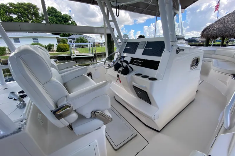 Slide: The Image of 2015 Edgewater 320CC boat interior with helm, white seating, and navigation equipment. - 19