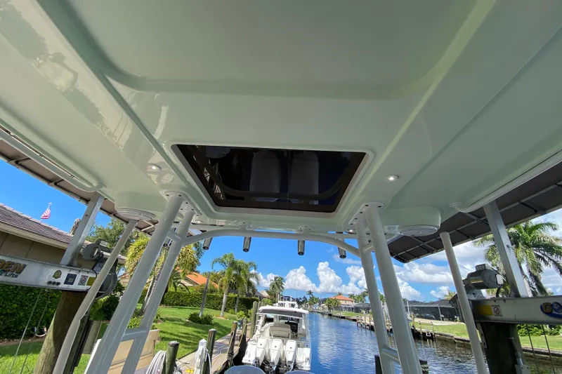 Slide: The Image of 2015 Edgewater 320CC boat interior view with canal and palm trees in background. - 24