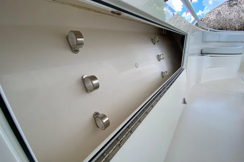 Slide: The Image of 2015 Edgewater 320CC boat storage compartment with metal fixtures, open view. - 26
