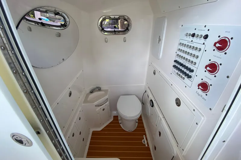 Slide: The Image of Interior of 2015 Edgewater 320CC boat featuring a compact bathroom with control panel. - 28